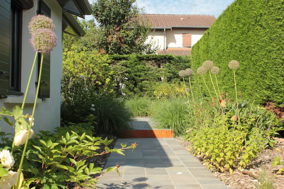 photo du réaménagement d'un jardin à Saint Didier au Mont d'Or. Création de carrés plantés : des plantations luxuriantes dans des lignes droites. Nous avons profité des légères différences de niveau pour créer un allée bordée de végétation et ponctuée de quelques marches.