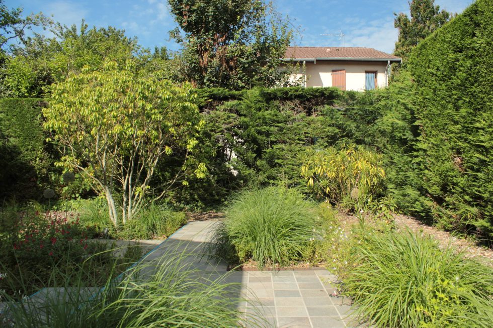 photo du réaménagement d'un jardin à Saint Didier au Mont d'Or. Création de carrés plantés : des plantations luxuriantes dans des lignes droites. Nous avons profité des légères différences de niveau pour créer un allée bordée de végétation et ponctuée de quelques marches.