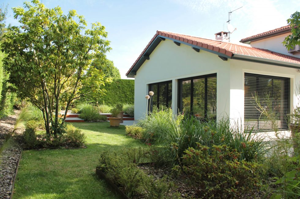 photo du réaménagement d'un jardin à Saint Didier au Mont d'Or. Création de carrés plantés : des plantations luxuriantes dans des lignes droites. Nous avons profité des légères différences de niveau pour créer un allée ponctuée de quelques marches.