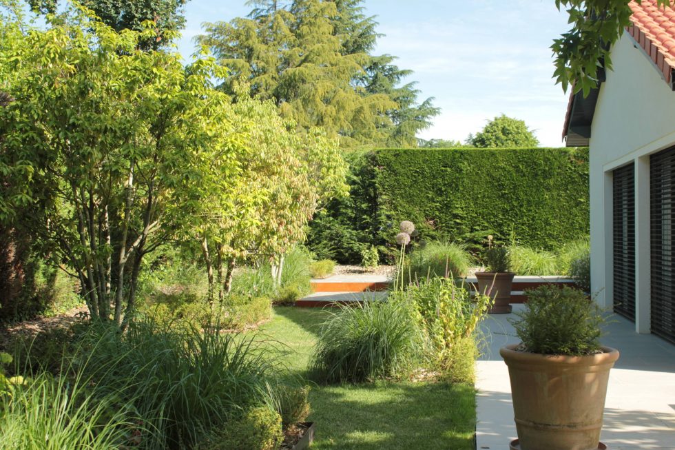 photo du réaménagement d'un jardin à Saint Didier au Mont d'Or. Création de carrés plantés : des plantations luxuriantes dans des lignes droites. Nous avons profité des légères différences de niveau pour créer un allée ponctuée de quelques marches.