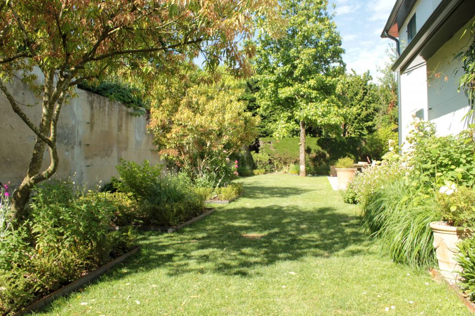 photo du réaménagement d'un jardin à Saint Didier au Mont d'Or. Création de carrés plantés : des plantations luxuriantes dans des lignes droites. Un jardin à contempler en toute saison.