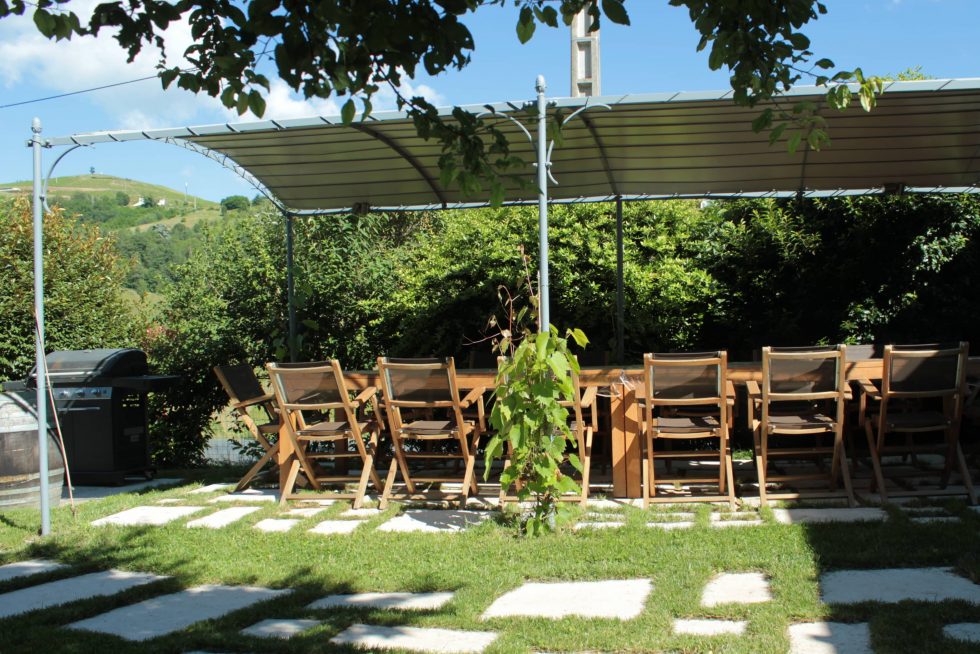 Création d'une terrasse en dalles de pierre naturelle, jointées d'herbe, pour un espace repas naturel.